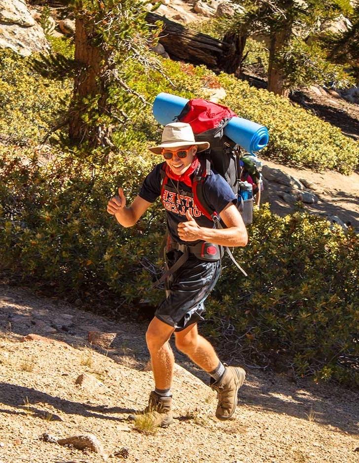 student wears hiking gear on an outdoor orientation adventure